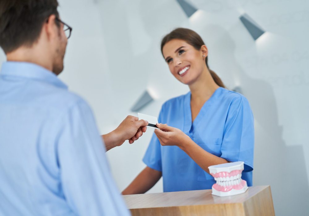Picture of male patient paying for dental visit in clinic
