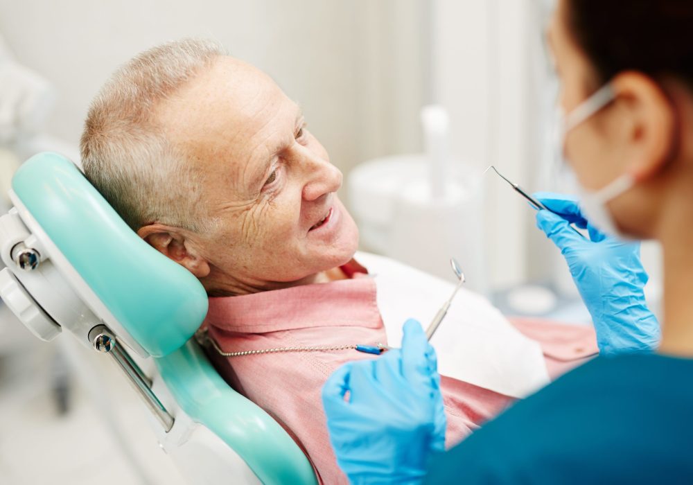 Aged man complaining about problems with teeth before dental check-up